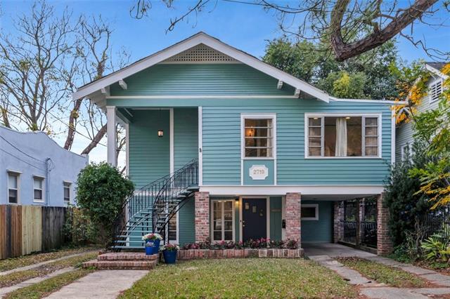 Raised craftsman-style home with a deep front porch on a Fountainebleau, New Orleans street